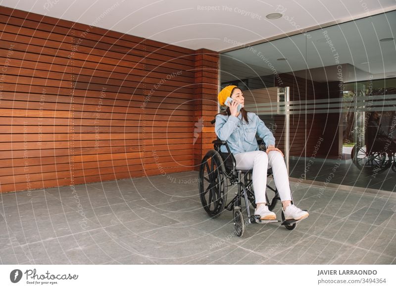 Behindertes Mädchen im Rollstuhl, das mit ihrem Handy telefoniert deaktivieren jung Frau Smartphone Technik & Technologie Mitteilung verletzt Lifestyle