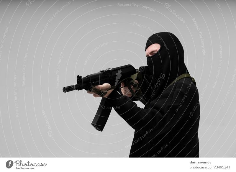 Mann in Maske mit Pistole auf weißem Hintergrund Aggression bewaffnet Sturmhaube schwarz Verbrechen Krimineller Gefahr böse Hand Beteiligung vereinzelt Mörderin