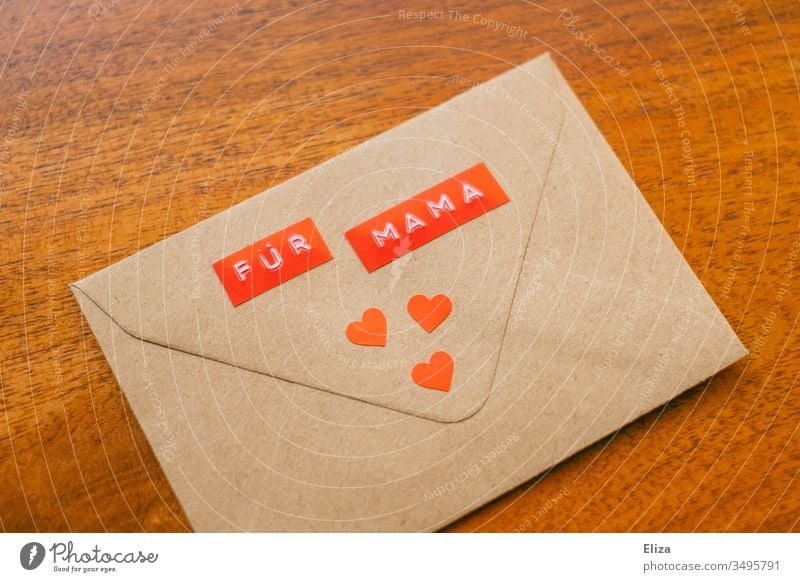 Ein Briefumschlag auf dem "Für Mama" steht mit roten Herzen dekoriert Muttertag Geschenk Liebe Zuneigung Post Kommunikation senden Nachricht braun Kommunizieren