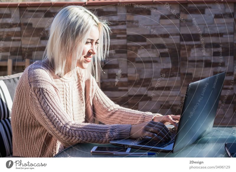 Studentin, die einen Laptop benutzt, während sie draußen auf der heimischen Terrasse sitzt. Frau jung heimwärts Mädchen Computer Glück Menschen Person Lifestyle