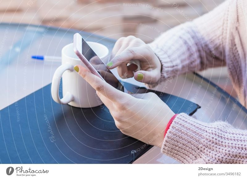 Makroaufnahme der Hände eines Mädchens, das Nachrichten auf einem Smartphone liest. Sie berührt den Touchscreen mit ihrem Finger, um die Seite umzublättern. 1