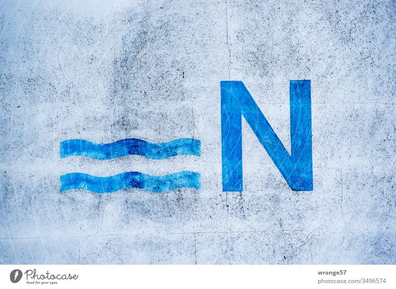 Großes blaues N und 2 Wellenlinien auf einer Hauswand Großbuchstabe Außenaufnahme Buchstaben Fassade Schriftzeichen Menschenleer Farbfoto Textfreiraum oben