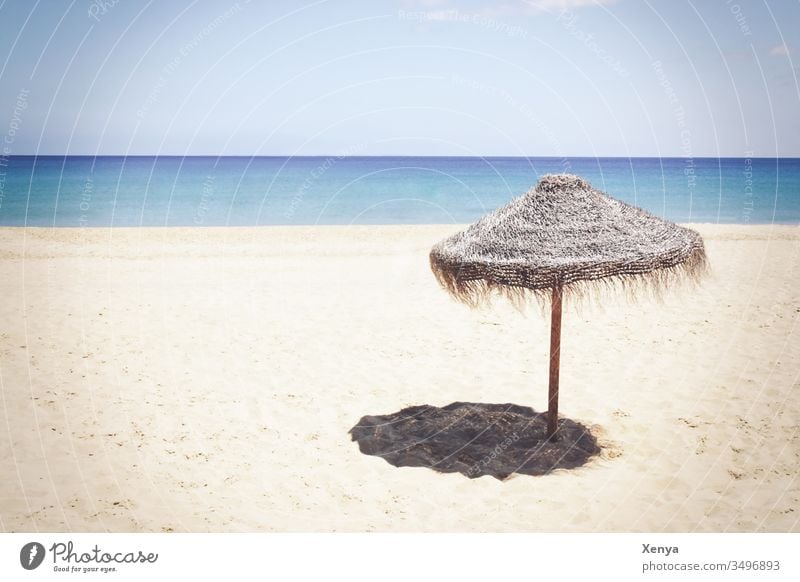 Einsamer Strand mit Sonnenschirm - ein lizenzfreies Stock Foto von
