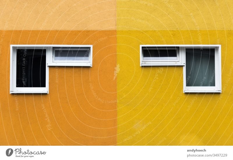 Ein Paar von zwei Fenstern an einer gelb-orangenen Fassade abstrakt Appartement Architektur Hintergrund Berlin Gebäude Gebäudeaußenseite gebaute Struktur