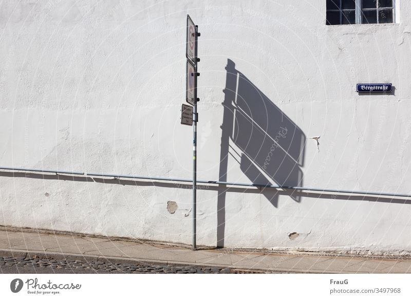 der Schatten neben den Schildern | Nebensache Wand Gebäude Fassade Fenster Sprossenfenster Straßenschild Bergstraße Putz abgeblättert Handlauf Gehweg