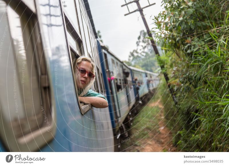 Blonde kaukasische Frau fährt im Zug und schaut durchs Fenster. reisen Verkehr Eisenbahn Blick Transport Abenteuer Passagier Reise im Innenbereich entspannend