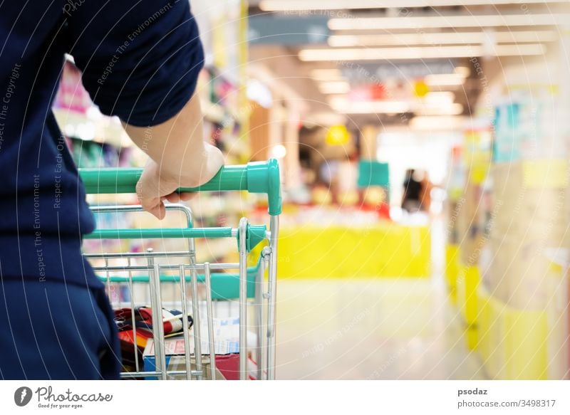 Einkäuferin mit Einkaufswagen mit verschwommener Bewegung eines Supermarkt-Kaufhauses Gang attraktiv Hintergrund Korb Business kaufen Karre Großstadt Gewerbe