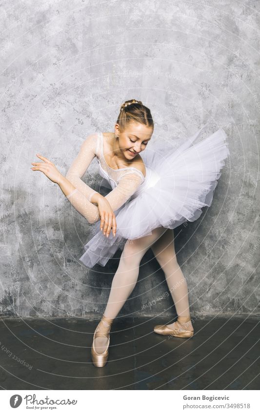 Hübsche junge Ballerina tanzt klassisches Ballett an rustikaler Wand Frau Tanzen Pose Tänzer Übung schön Schuhe Kleid Gleichgewicht Aktion Künstlerin