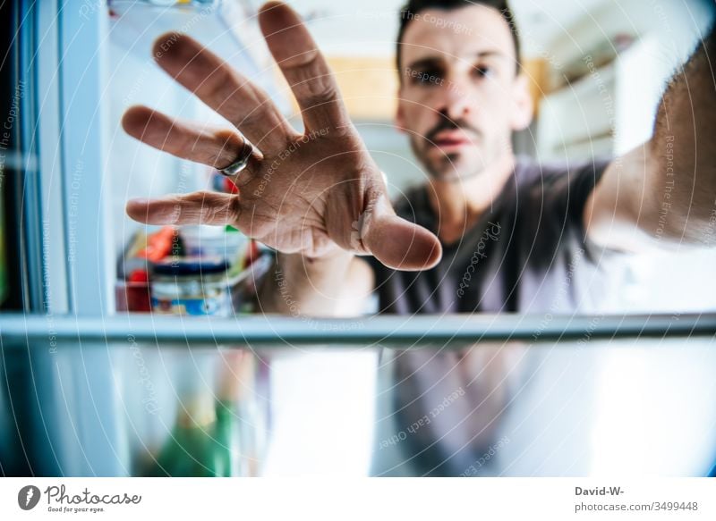 Griff in den Kühlschrank greifen Hand essen naschen Hunger Kühlschranktür öffnen herausnehmen herausholen Perspektive kreative Kreativität groß öffnend offen