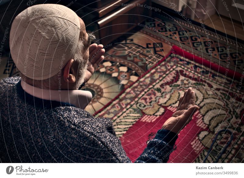 Sehr alter türkisch-muslimischer Mann in den 80er Jahren, der zu Hause auf seinem Teppich zu Allah betet älter männlich Person beten Gebet betend Gebetshaube