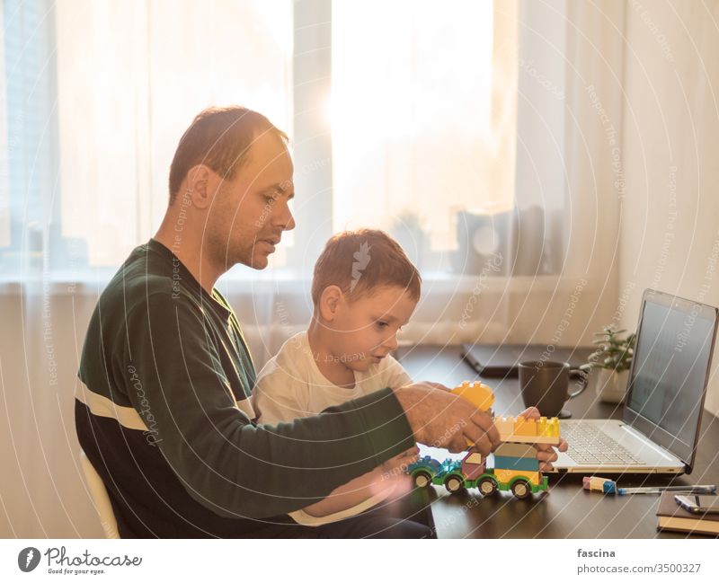 Konzept der Fernarbeit unter Kindern aus der Ferne arbeiten vier Jahr alt Junge spielen Laptop Gebäude Kulisse Papa die Werk heimwärts Coronavirus Quarantäne