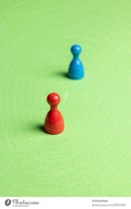 Zwei Spielfiguren mit Abstand, Social Distance. rot blau grün abstand Nahaufnahme Farbfoto Spielzeug Spielen social distancing social distance virus