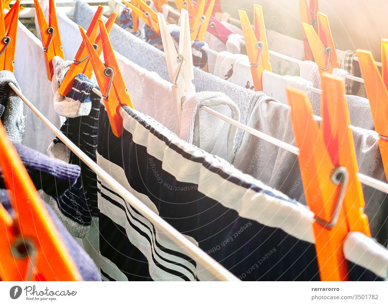 eine Gruppe von orangefarbenen Wäscheklammern auf einem Trockengestell zum Trocknen der Wäsche. Wäsche, die zum Trocknen in einem Haus aufgehängt wurde. Hausarbeit und Hygiene.