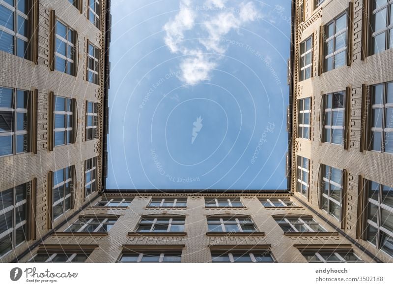 Ein Blick auf eine weiße Wolke von einem Innenhof Appartement Appartements Architektur schön blau Blauer Himmel Baustein Gebäude Großstadt Wolken Konstruktion