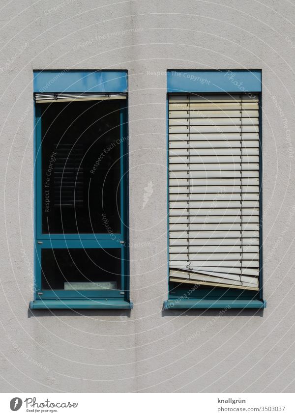 Zwei schmale Fenster mit blauen Rahmen, eines mit heruntergelassener Jalousie, etwas schief Sichtschutz schräg Fensterrahmen 2 Muster Außenaufnahme geschlossen
