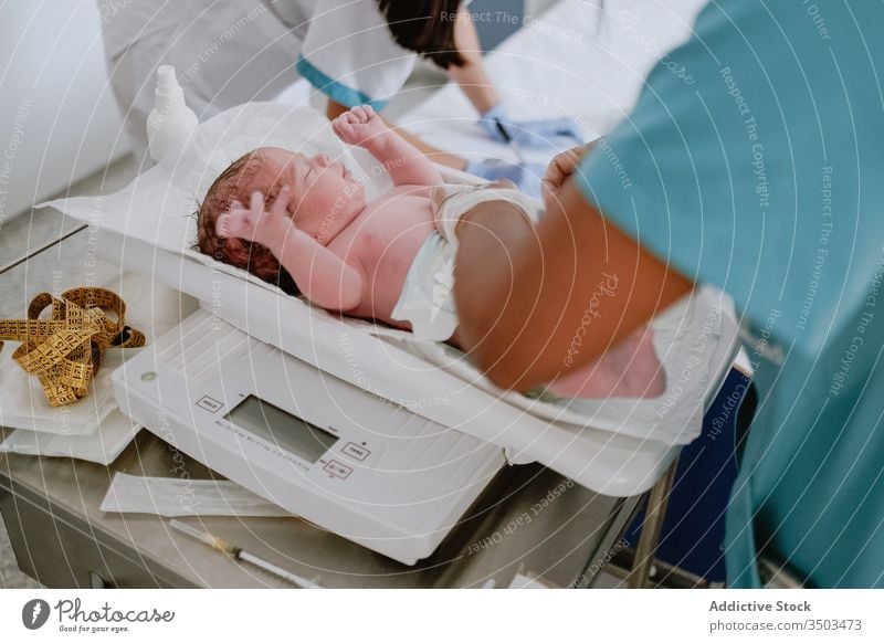 Krankenschwester untersucht Neugeborenes im Krankenhaus neugeboren Baby Gewicht Skala Klinik nach der Geburt untersuchen Pflege Gesundheit Kind Gesundheitswesen