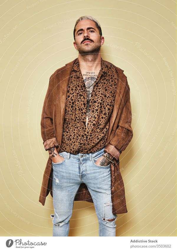 Trendiger ethnischer Typ in modischem Outfit im Studio stehend Mann trendy Stil Mode Leopard Mantel Model Jeanshose Vollbart männlich Stoff modern cool