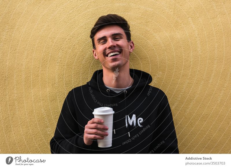 Fröhlicher Mann mit Getränk zum Ausruhen auf die Strasse Straße modern Imbissbude soziale Netzwerke Großstadt sich[Akk] entspannen Außenseite horizontal Kaffee
