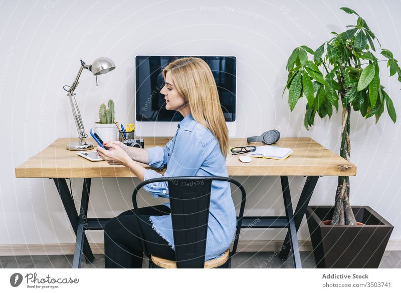 Blonde Kaukasierin arbeitet von ihrem Heimbüro aus Frau Arbeit Browsen Computer Tippen Schreibtisch heimwärts Mitteilung Geschäftsfrau Business Tablette Büro