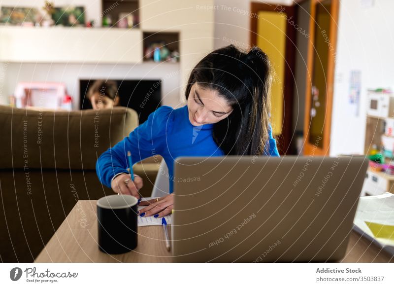 Weibliche Freiberuflerin, die zu Hause arbeitet Frau freiberuflich heimwärts schreiben Hinweis Papier Fokus Arbeit Projekt abgelegen Laptop Tisch Job gemütlich