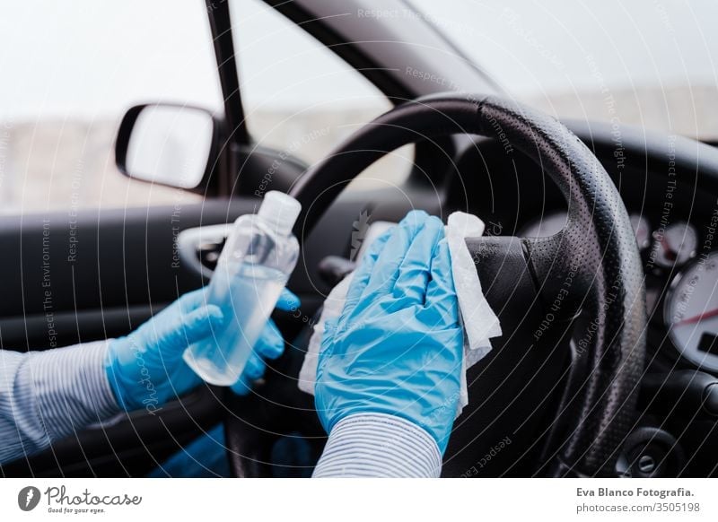 unerkannter Mann in einem Auto, der während der Pandemie des Coronavirus covid-19 Alkohol-Gel zur Lenkraddesinfektion verwendet PKW Desinfektion bekommen