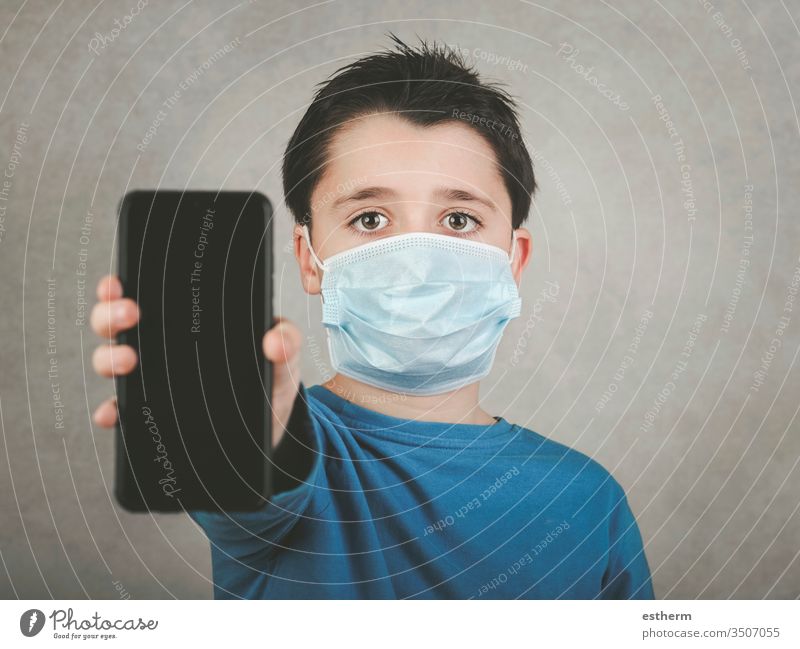 Kind mit medizinischer Maske und Smartphone Coronavirus Virus 2019-ncov Seuche covid-19 Pandemie Quarantäne Symptom Medizin digital Computer Mitteilung