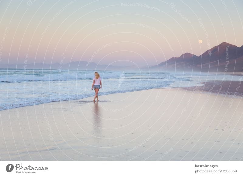 Dame beim Spaziergang am Sandstrand im Sonnenuntergang. Frau MEER Strand Landschaft Küstenlinie Fußspur Fußtritt Urlaub Wasser Natur Sommer Wellen schön Meer