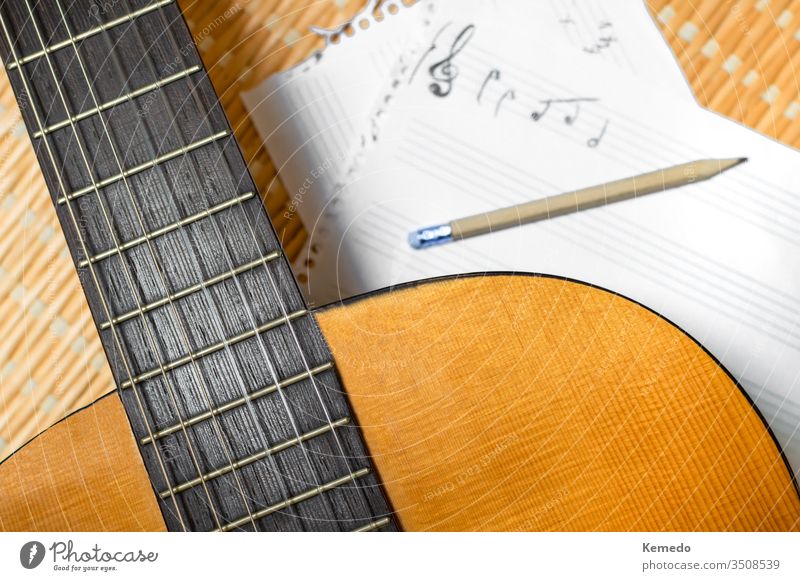 Draufsicht auf eine klassische Gitarre, Notenheft mit Notenlinien und Bleistift. Konzept des Komponierens oder Musikstudiums. komponieren Stab Musical Notebook