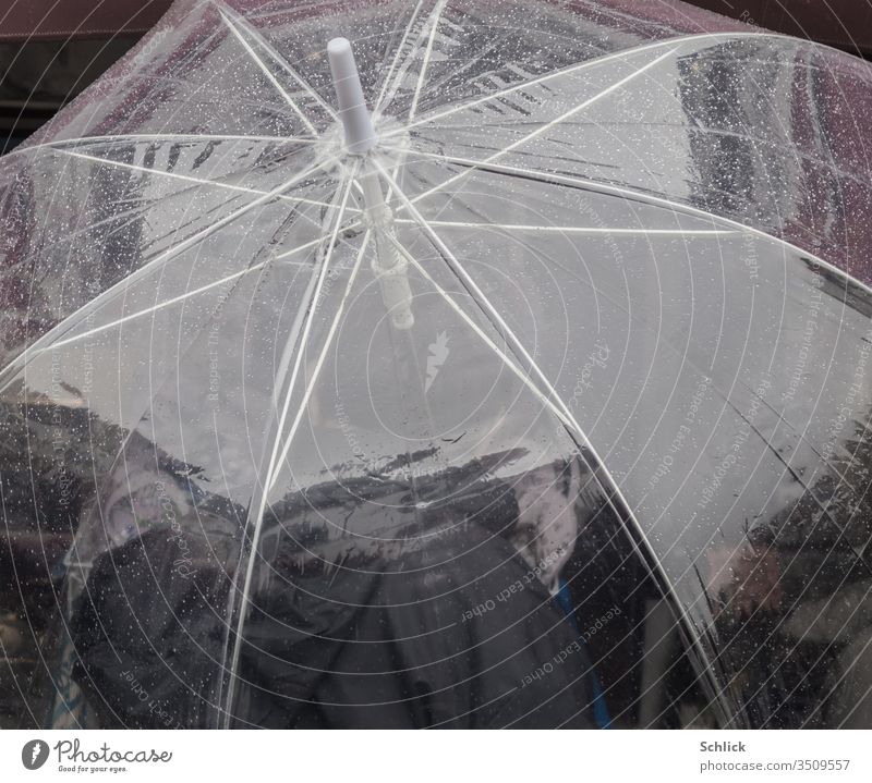 Transparenter Regenschirm mit Regentropfen von schräg oben fotografiert transparent Wassertropfen durchsichtig Mensch Person Polyurethan Kunststoff Folie