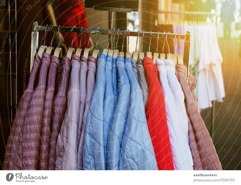 Kleiderständer mit Steppjacken für Damen, die vor dem Geschäft hängen Damenbekleidung Mode Kleidung steppjacke Bekleidung Jacke Frühling Laden Werkstatt Anzeige