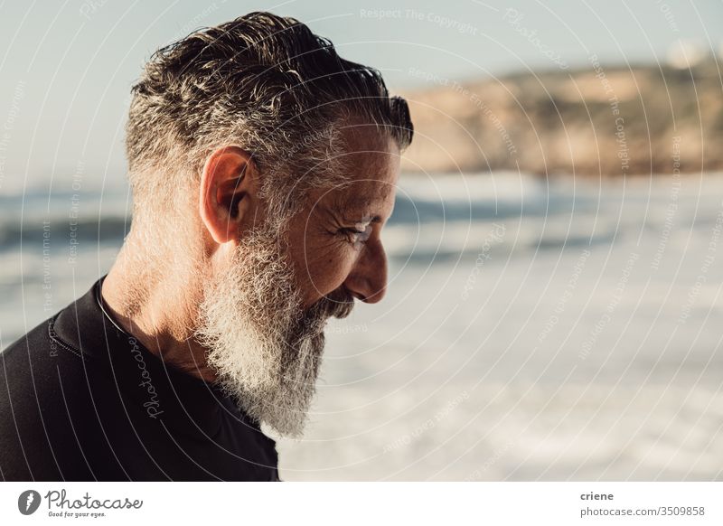 Älterer Mann mit langem Bart lächelt am Strand Senior Männer Urlaub Surfen Erwachsener Lächeln graue Haare Lifestyle Freude Sport Hobby Porträt Vollbart