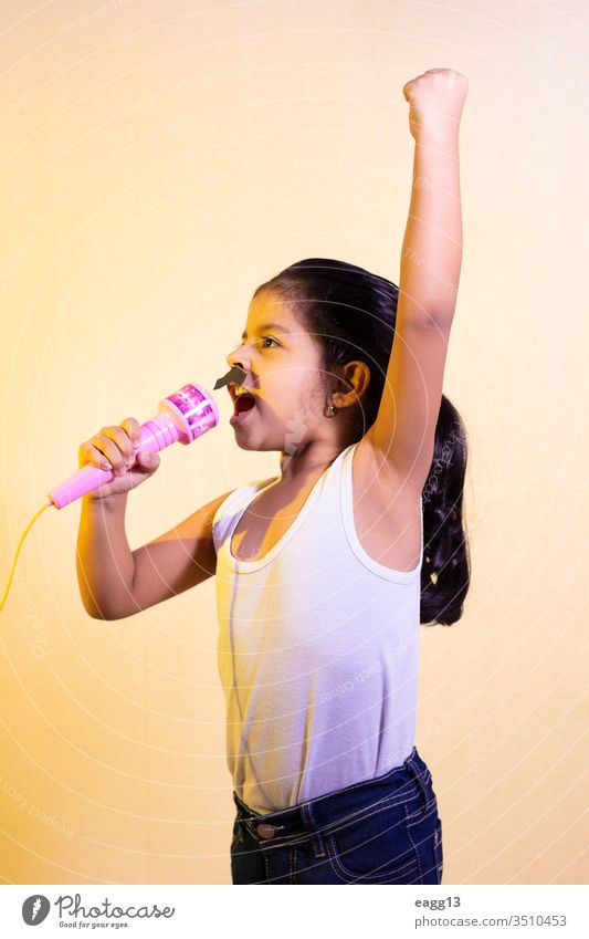 Kleines Mädchen mit Schnurrbart singt mit ihrem Mikrofon Karneval blitzen Einstellung feiern zu feiern Kinder bequem Konzepte cool Tracht Deckung Kreativität
