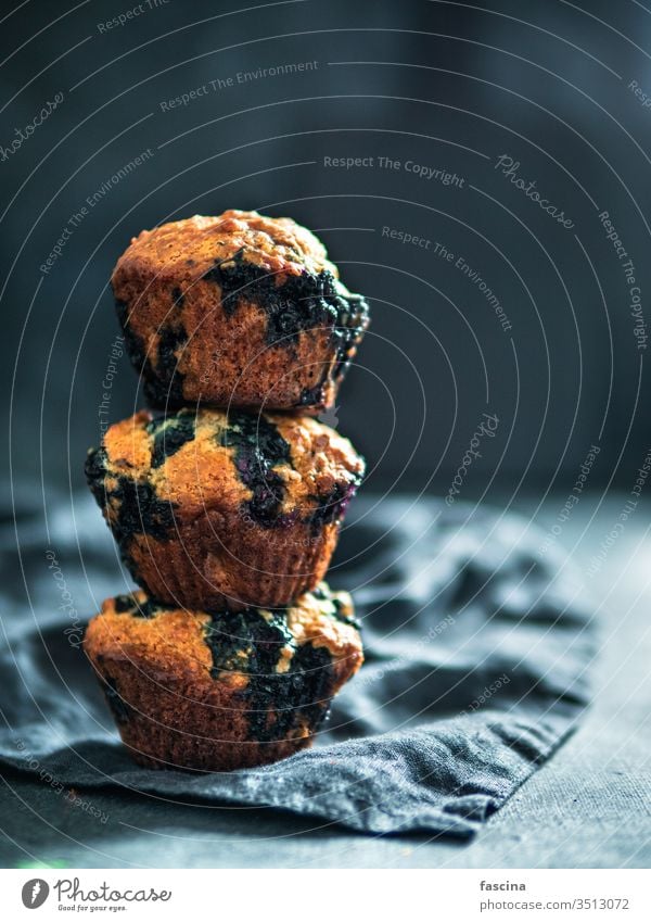 Hausgemachte Blaubeer-Muffins auf dunklem Hintergrund. kalorienarm selbstgemacht Blaubeeren drei Stapel niemand Draufsicht oben vertikal Lebensmittel Dessert