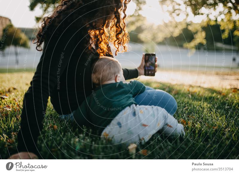 Mutter und Baby beim Selbstauslöser-Foto Technik & Technologie Smartphone Selfie fotografierend Zusammensein Lifestyle Leben Freude Lächeln Außenaufnahme