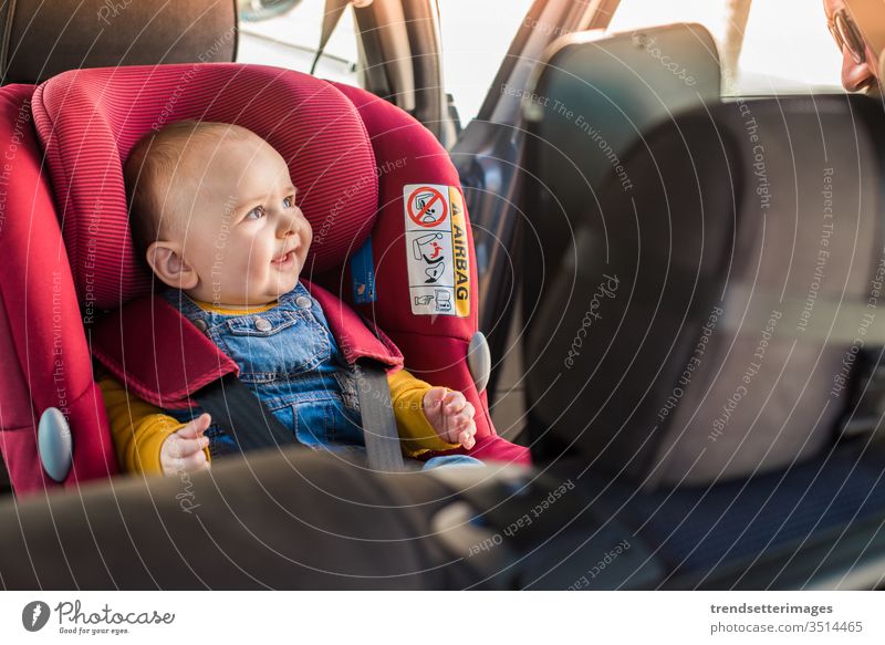 Vater schnallt sein Baby im Autositz an isofix Schnappriegel PKW Sitz Kind befestigen Sicherheit Gurt Schutz Transport Fahrzeug Familie reisen Menschen Glück