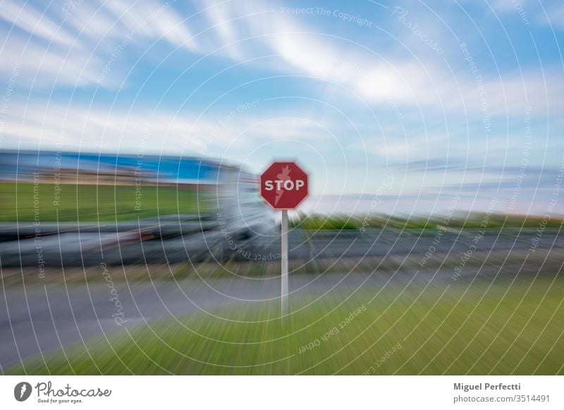 "Stopp"-Verkehrszeichen und ein fahrender Lastwagen auf der Straße, alles unter einem Zoom-Effekt Verkehrsgebot stoppen Zeichen Stoppschild Symbol Ermahnung
