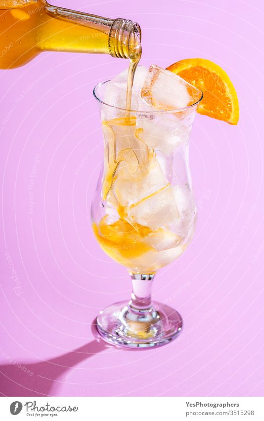 Gießen Sie Orangensirup in ein Glas mit Eiswürfeln. Limonade herstellen Getränk hell Nahaufnahme Cocktail Erfrischungsgetränk farbenfroh lecker Entzug