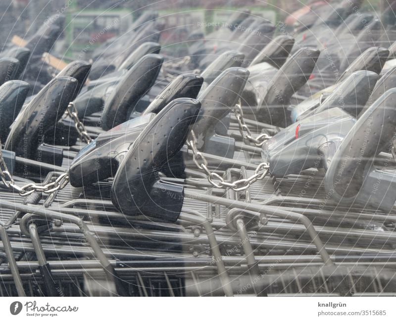 Schwarze Griffe von Einkaufswagen die miteinander verbunden sind zusammen Kettenglied Metall Reflexion & Spiegelung Farbfoto Außenaufnahme Menschenleer