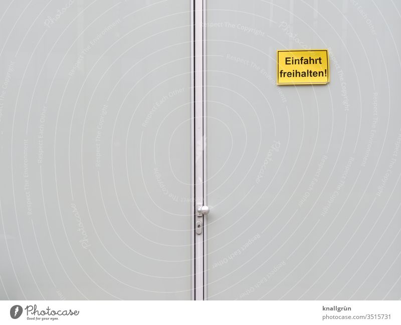 Große Doppeltür mit „Einfahrt freihalten“ - Schild rechts oben Schilder & Markierungen Tür Tor Hinweisschild Außenaufnahme Warnschild Kommunizieren Mitteilung