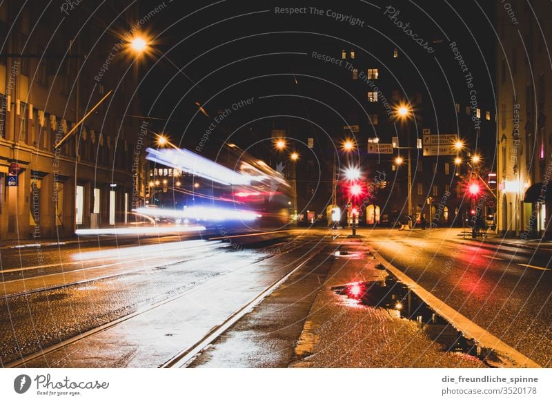 Straßenbahn bei Nacht Regen Langzeitbelichtung Laterne Stadt urban Blendeneffekt Licht dunkel Verkehr Bewegung Lichtzieher Geschwindigkeit Beleuchtung Mobilität