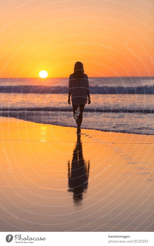 Dame beim Spaziergang am Sandstrand im Sonnenuntergang. Strand MEER Frau Sommer Fußspur Fußtritt Landschaft Küstenlinie Urlaub Wasser Natur Wellen schön Meer