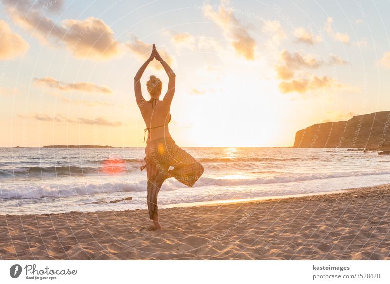 Frau, die bei Sonnenuntergang am Meeresstrand Yoga praktiziert. Strand Frieden Mädchen Körper sich[Akk] entspannen MEER Gesundheit Übung Sonnenaufgang