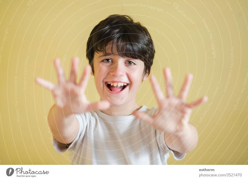 Glückliches Kind streckt die Hände hoch, Hintergrund verschwommen sich ausbreiten zeigend Lächeln Freude Zeichen Euphorie euphorisch schreien heiter Energie