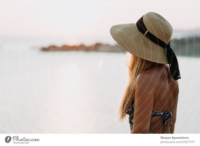 Junge Frau genießt Sonnenuntergang am Meer Abenteuer schön Schönheit sorgenfrei Klippe Küste Küstenstreifen Küstenlinie genießend Abend Freiheit Mädchen Hut