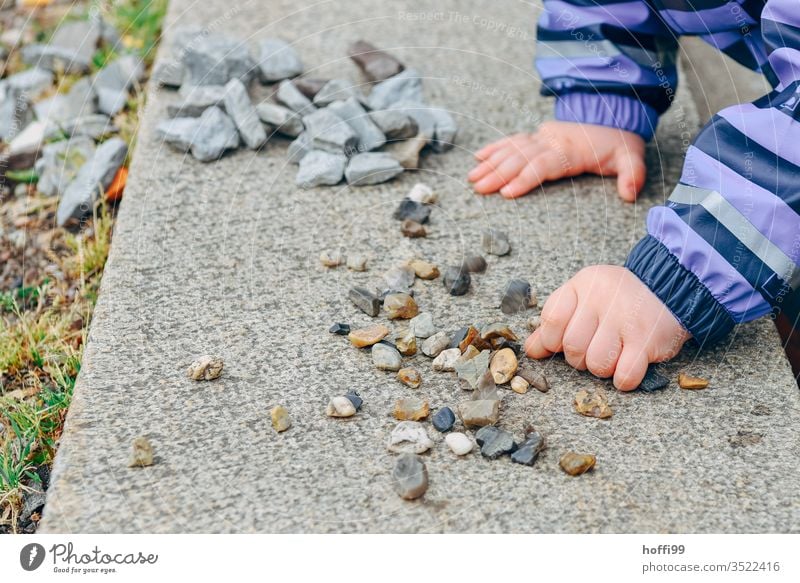 Kinderhände sortieren kleine Steine auf einer Mauer Kinderhand Spielen Hand Kindheit Kleinkind Farbfoto Finger 1-3 Jahre Detailaufnahme 3-8 Jahre Freude