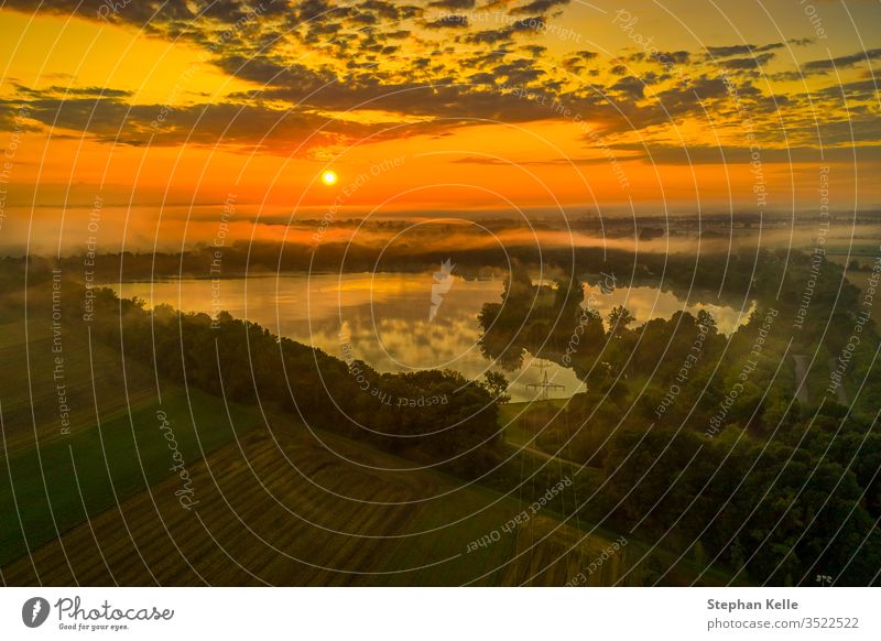 Herrlicher Sonnenaufgang über einem vernebelten See, orangene Farbgebung Aufgang Morgen Nebel ruhig Wasser Morgendämmerung Himmel Natur Reflexion & Spiegelung