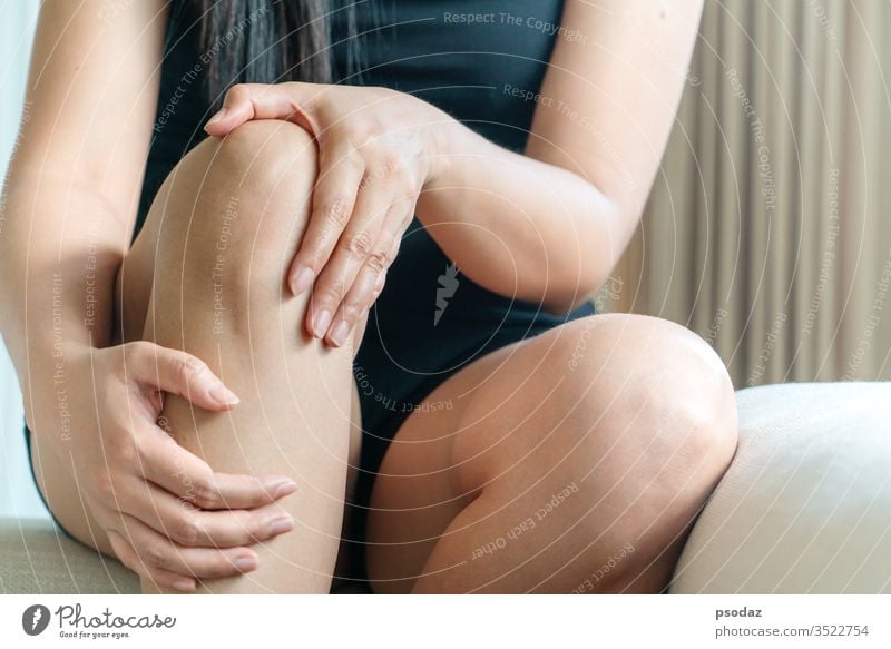 Frauen Knie schmerzhaft, Frauen berühren das schmerzhafte Knie zu Hause Unfall Schmerzen Fußknöchel Arthritis Asien Athlet Schönheit Körper Knochen gebrochen