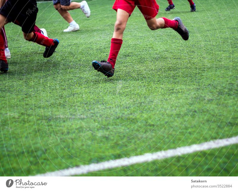 Die Fussballer treten in farbigen Sportarten der Grundschule an Fußball Kinder Schule Spiel grün Streichholz spielen Junge jung Hintergrund Feld Spieler