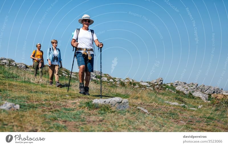 Drei Personen, die Trekking im Freien praktizieren Wanderer lokaler Tourismus Familie Landschaft laufen Trekkingstöcke Senior Natur Nordic Walking Sommer