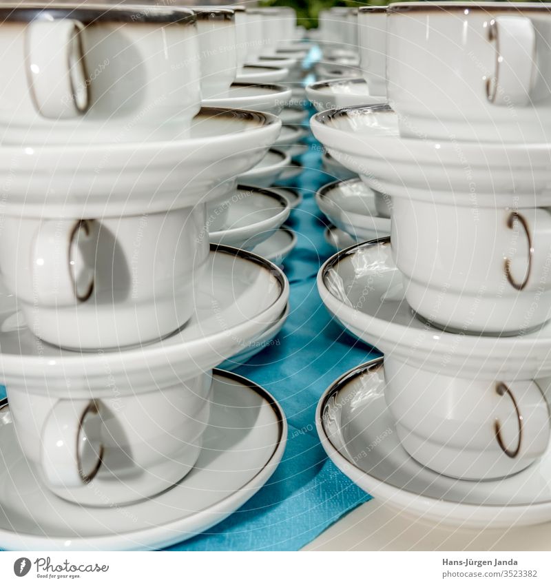 Weiße Kaffeetassen mit Tellern stehen in einer Reihe gestapelt Becher weiß Utensilien trinken Feier Restaurant Pause Kuchen Pub Genuss Serviette blau gemütlich